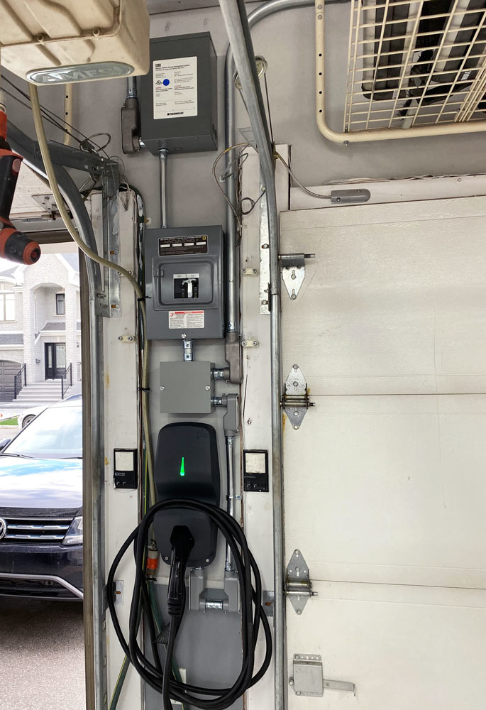 DCC-12 EV Energy Management System load controller installed next to subpanel