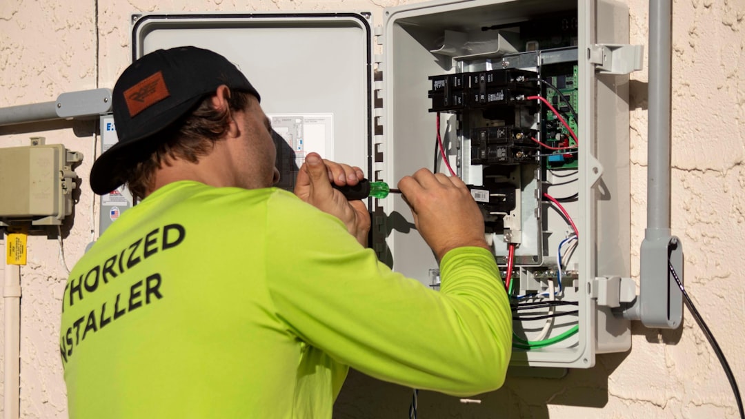 An electrical panel with open cover showing circuit breakers, dimly lit