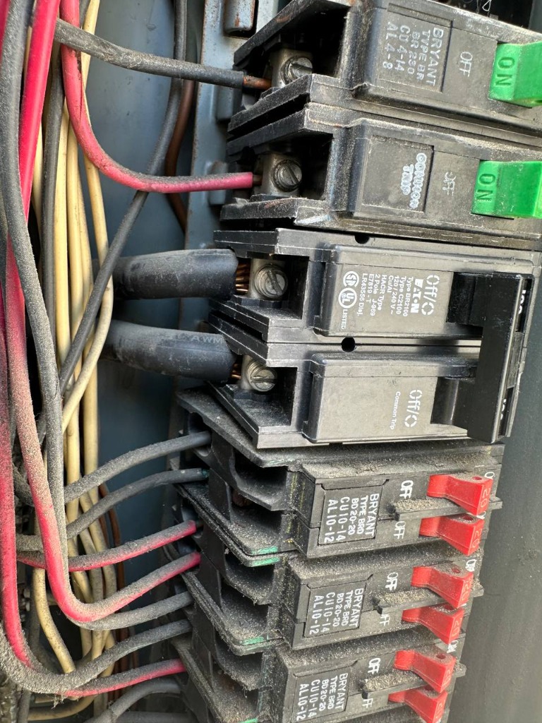 Overloaded 100-amp electrical panel with a tripped breaker